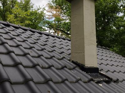 Komín na míru z tvárnic na nové vlnité černé střeše | Stavba zděných komínů Brno